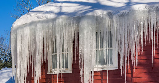 ice dam on home roof causing damage without seamless gutters
